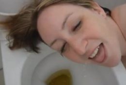 Brunette drinking piss over toilet