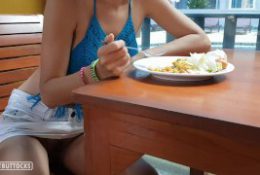 Girl with red hair sits without panties in a public dining room